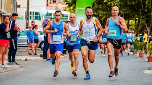 Zróżnicowana grupa sportowców biorących udział w maratonie ulicznym, prezentująca wytrzymałość i sprawność fizyczną.