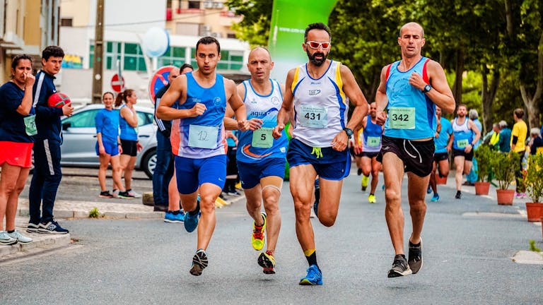 Zróżnicowana grupa sportowców biorących udział w maratonie ulicznym, prezentująca wytrzymałość i sprawność fizyczną.