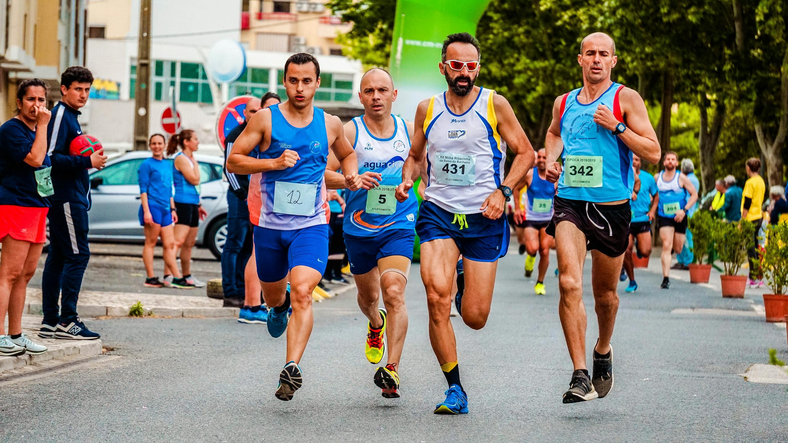 Zróżnicowana grupa sportowców biorących udział w maratonie ulicznym, prezentująca wytrzymałość i sprawność fizyczną.