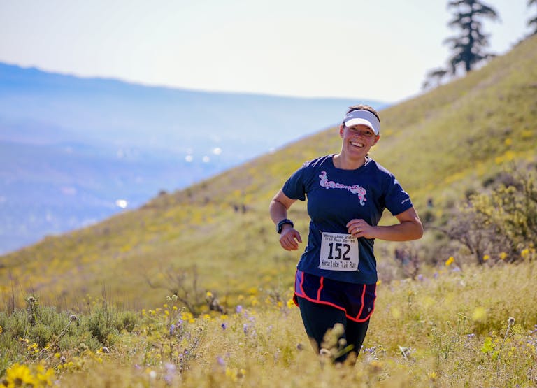 Kobieta podczas maratonu trailowego na tętniących życiem wzgórzach Wenatchee w stanie Waszyngton.