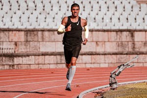 Skupiony biegacz podczas wyścigu na bieżni, pokazujący determinację i wytrzymałość.
