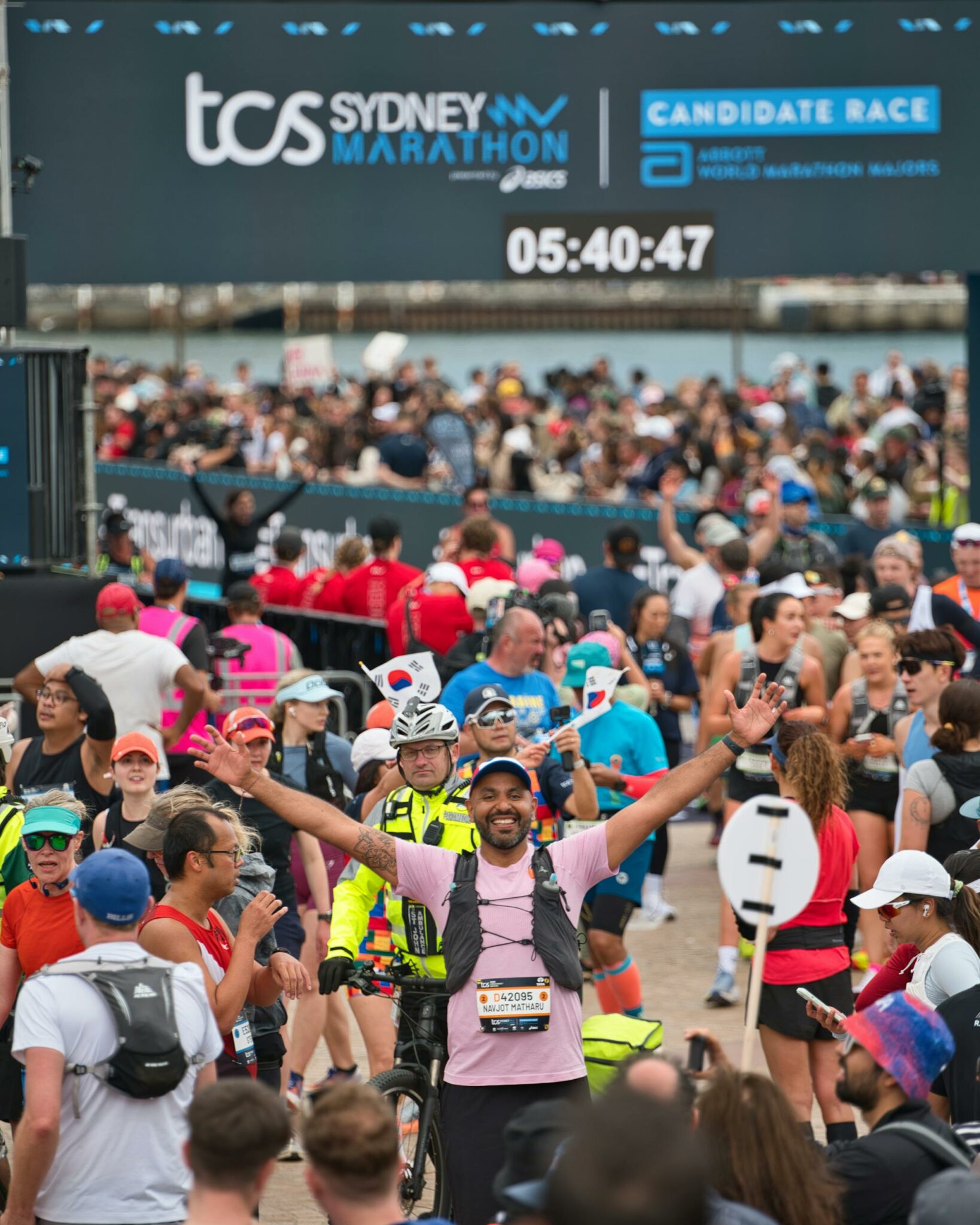 Radośni uczestnicy przekraczający linię mety podczas maratonu w Sydney, uchwyceni w emocjonującym momencie.