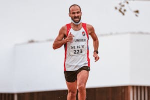 Zdeterminowany sportowiec biegający na świeżym powietrzu, prezentujący swoją sprawność fizyczną i wytrzymałość.