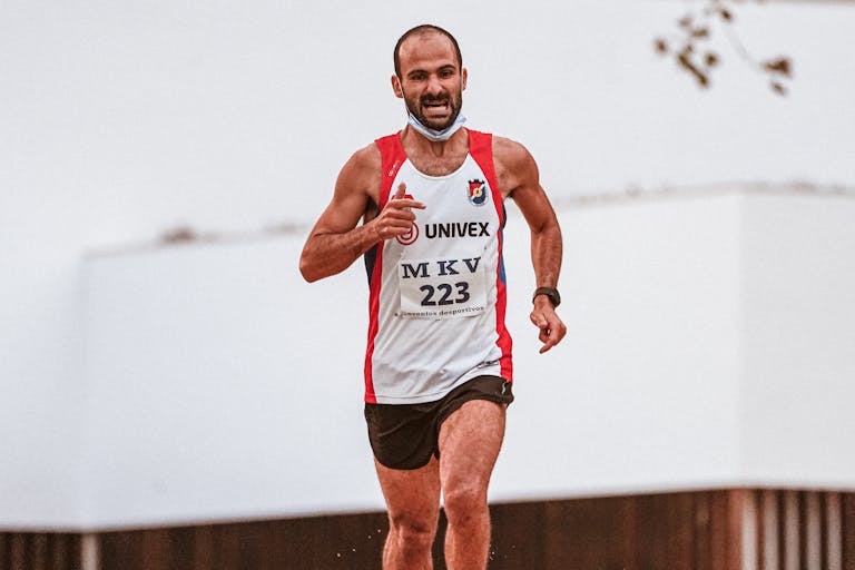 Zdeterminowany sportowiec biegający na świeżym powietrzu, prezentujący swoją sprawność fizyczną i wytrzymałość.